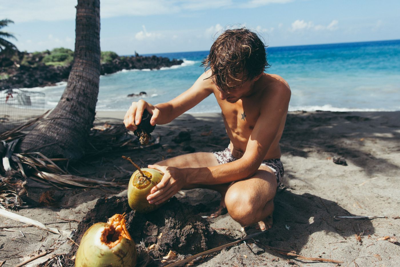 Man opening fresh cononuts, Pohue Bay Beach, Ocean View, Big Island, Hawaii