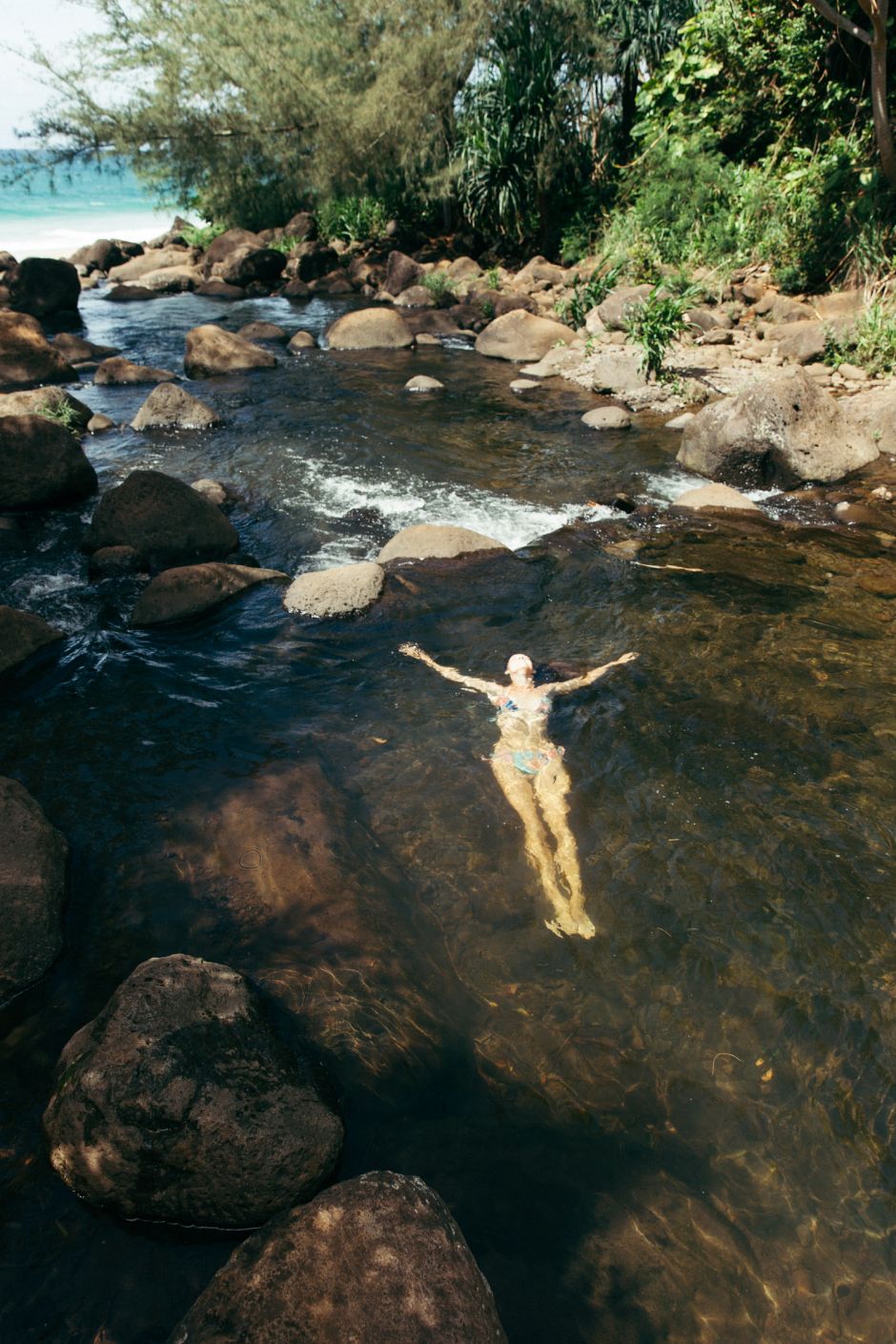 Woman swimming in Hanakapiai Stream, Kalalau Trail, Kaua'i, Hawaii