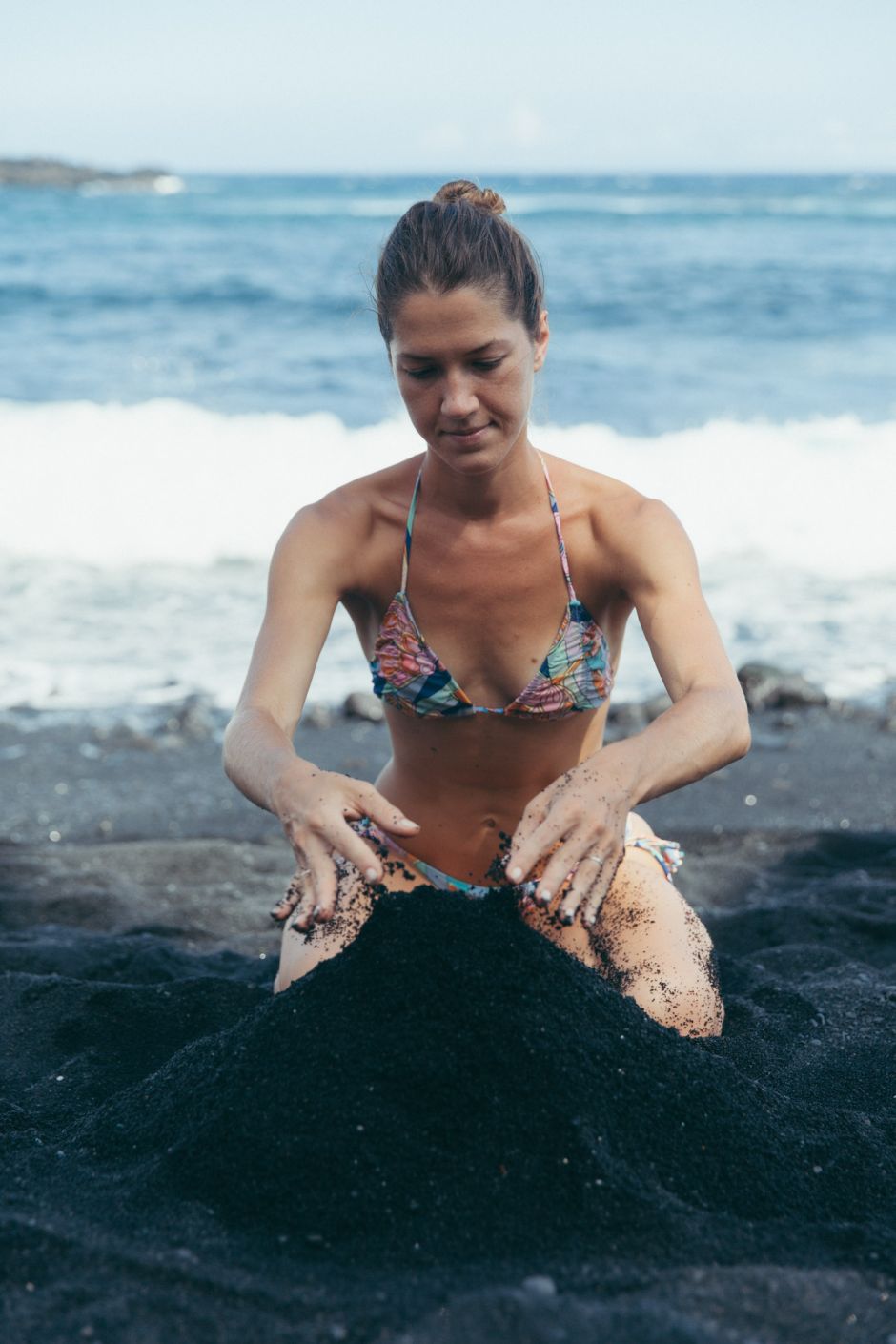 Girl playing with black sand, Punaluu Black Sand Beach, Big Island, Hawaii